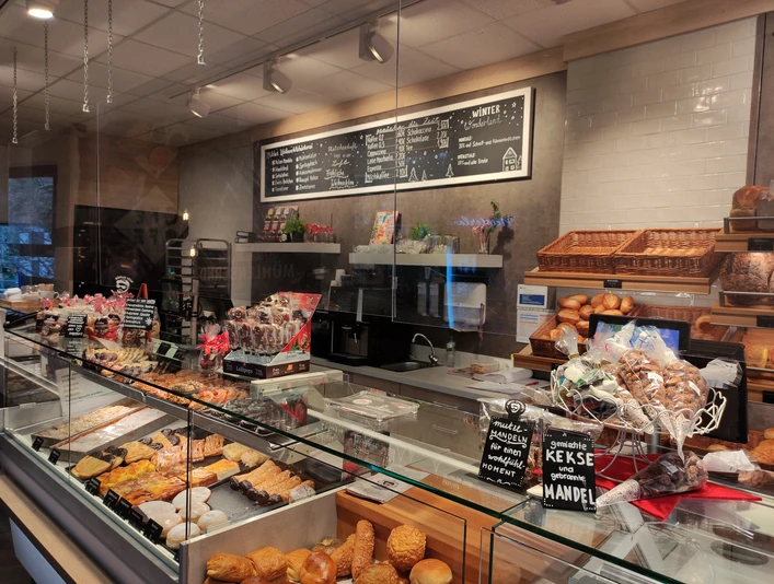 Tresen im Backparadies Mühlenbernd. Im Vordergrund sind Kekse zu sehen, in der Auslage süßes Gebäck.