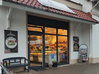 In der Mitte der Eingangsbereich zur Bäckerei, links und rechts Werbebanner