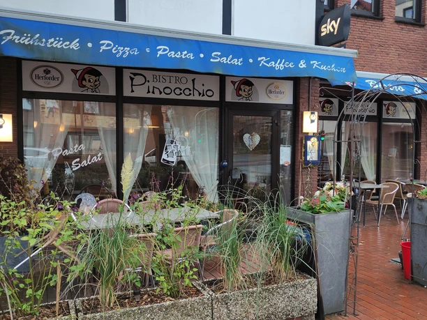 Außenbereich des Bistros Pinocchio, im Vordergrund sind Pflanzkübel