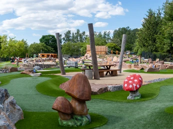 Minigolfanlage Stausee Oberwald Grüne Minigolfanlage mit Naturthemen, Pilz- und Baumdekorationen, unter blauem Himmel.Green minigolf course with nature themes, mushroom and tree decorations, under a blue sky.Zelené minigolfové hřiště s přírodními motivy, houbami a stromovými dekoracemi, pod modrou oblohou.Zielone pole do minigolfa z motywami natury, dekoracjami z grzybów i drzew, pod błękitnym niebem.Groene minigolfbaan met natuurthema's, paddenstoel- en boomdecoraties, onder een blauwe hemel.Campo da minigolf verde con temi naturalistici, decorazioni di funghi e alberi, sotto un cielo azzurro.