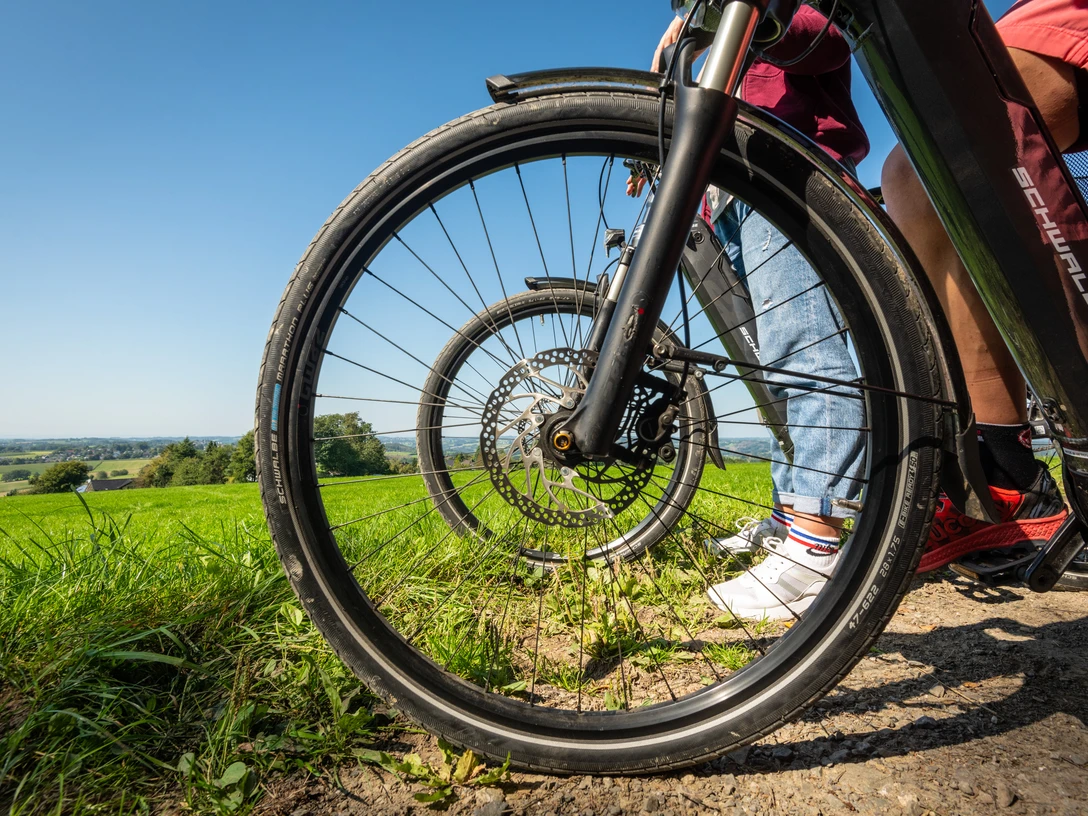 Heckberg Fahrräder parken auf einem sonnigen Weg mit grünen Feldern und blauem Himmel im Hintergrund.