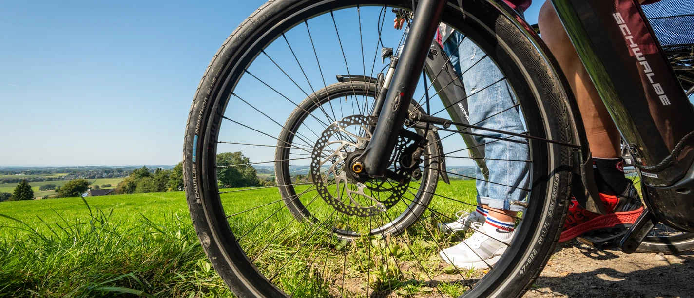 Heckberg Fahrräder parken auf einem sonnigen Weg mit grünen Feldern und blauem Himmel im Hintergrund.