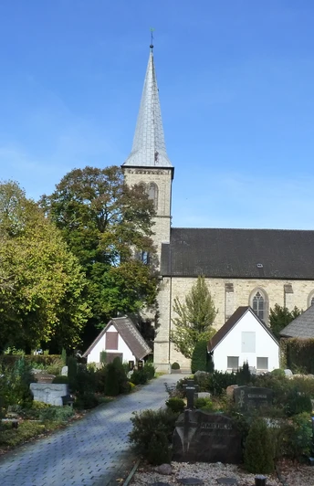 Pfarrkirche St. Margaretha und Friedhof in Dahl Pfarrkirche St. Margaretha in Dahl mit gravierten Grabsteinen, umgeben von Bäumen bei sonnigem Himmel.
