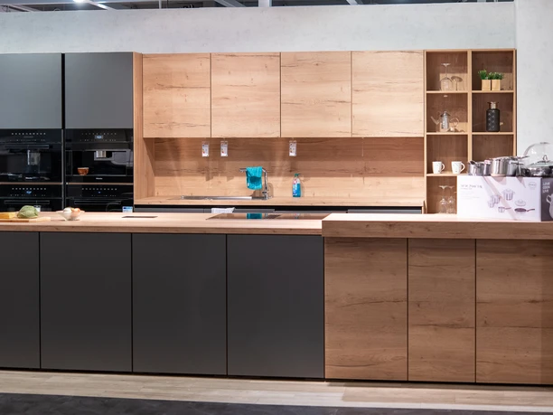 Eine moderne Küche mit dunkelgrauen und Holzfronten