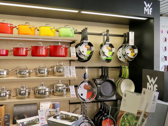 Pfannen und bunte Töpfe an einer Wand