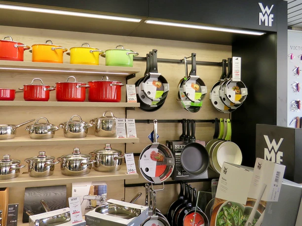 Pfannen und bunte Töpfe an einer Wand