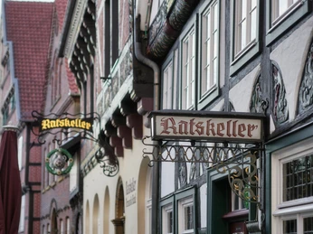 Fachwerkhäuser mit traditionellen "Ratskeller"-Schildern in einer malerischen, deutschen Altstadt.