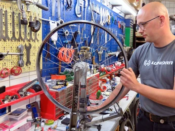 Henze_0008.jpg Manuel Schumann in der Werkstatt, arbeitet an einem Rad