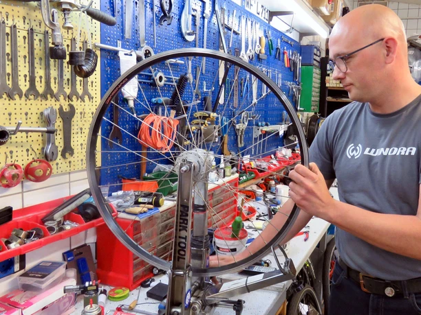 Henze_0008.jpg Manuel Schumann in der Werkstatt, arbeitet an einem Rad