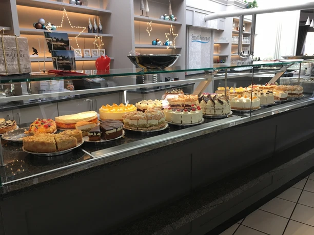 Konditorei-Theke mit köstlichen, kunstvoll verzierten Torten und Kuchen, appetitlich präsentiert.
