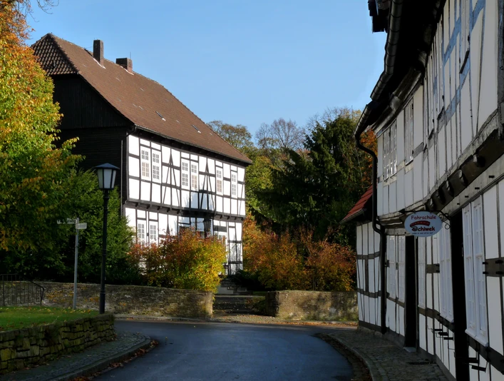 Levern Fachwerkhäuser in Levern mit Herbstlaub, gepflasterte Straße und klare blaue Himmel im Hintergrund.