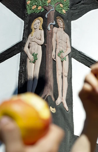 hx-stadtentdecken-andreashub (3).jpg Fachwerkhaus mit Relief von Adam und Eva; im Vordergrund Personen mit Äpfeln in den Händen.