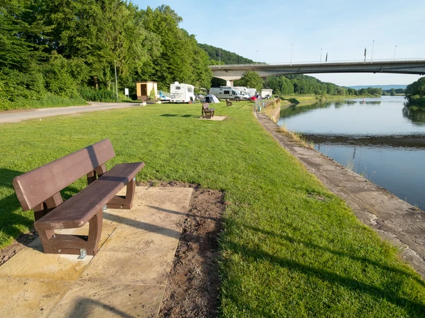 Vlothoer Hafen Vlothoer Hafen, vorne eine Bank, dann eine Wiese mit Wohnmobilen. Hinten ist die Weserbrücke