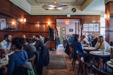 Vue de la salle de restaurant du café Grundmann avec des meubles de café classiques en bois