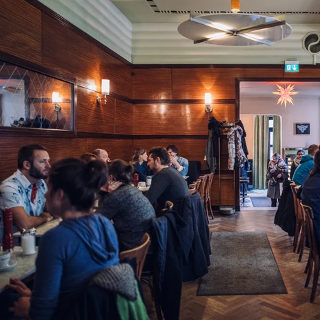 Vue de la salle de restaurant du café Grundmann avec des meubles de café classiques en bois