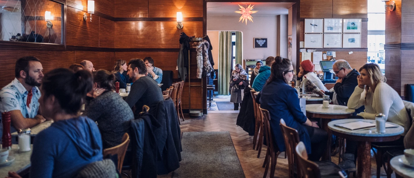 View into the guest room of the Cafe Grundmann with classic wooden coffee house furniture