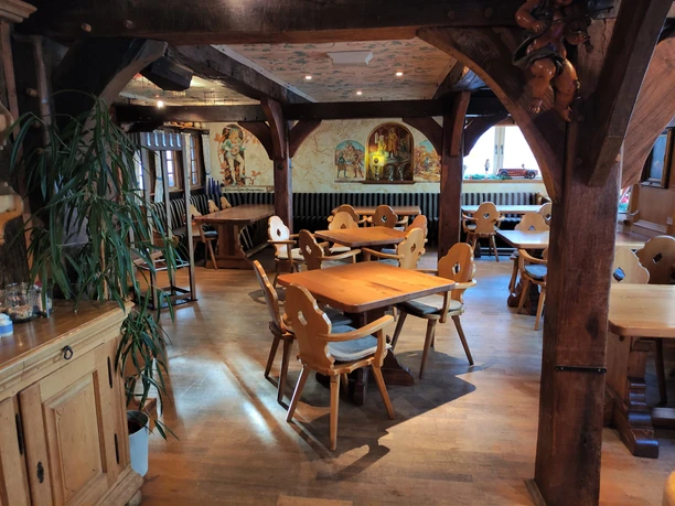 Holztische und Stühle im Gastraum
