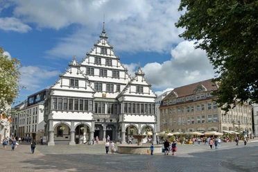 Rathausplatz Paderborn Historisches Rathaus in Paderborn mit markantem Giebel, umgeben von Besuchern auf dem belebten Platz.