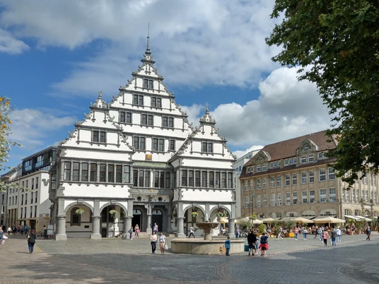 Rathausplatz Paderborn Historisches Rathaus in Paderborn mit markantem Giebel, umgeben von Besuchern auf dem belebten Platz.