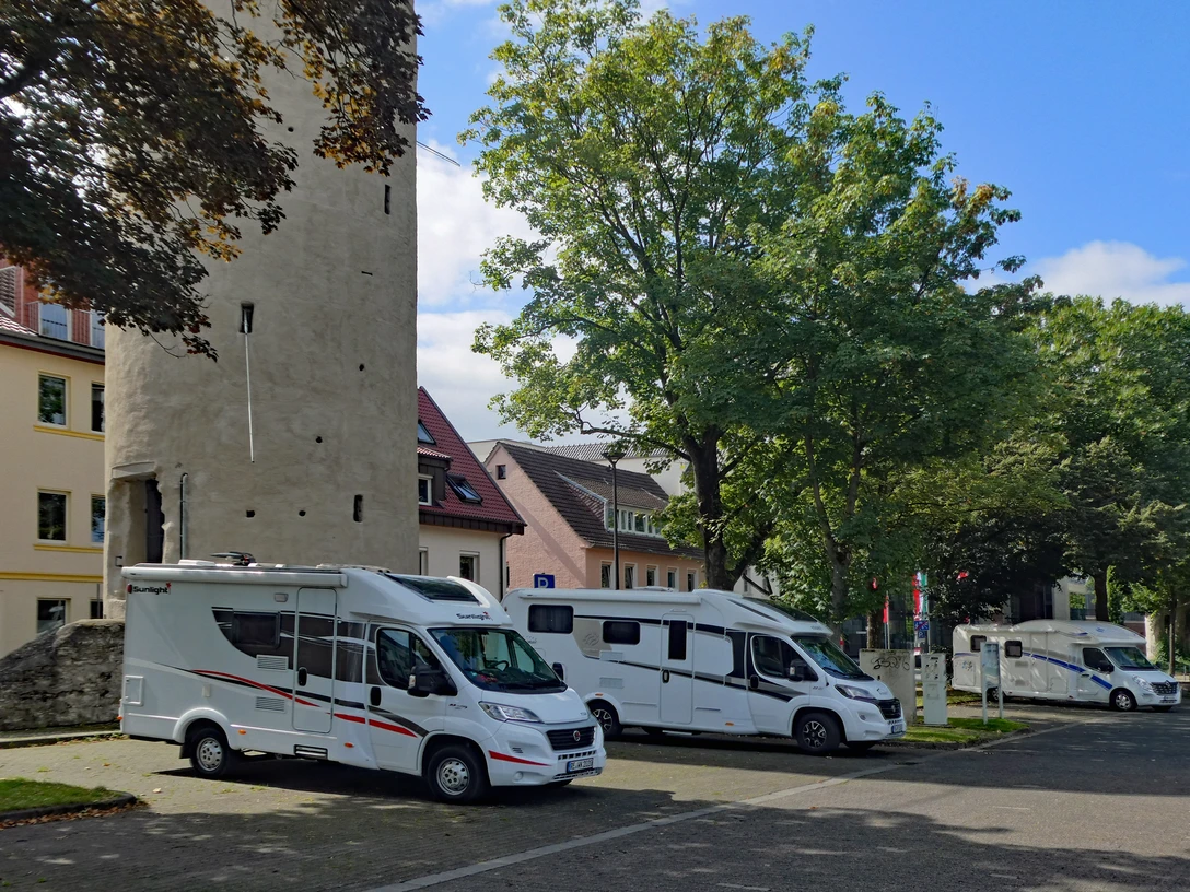 Wohnmobilstellplatz am Maspernplatz in städtischer Umgebung, nahe historischer Turm und viel Grün.