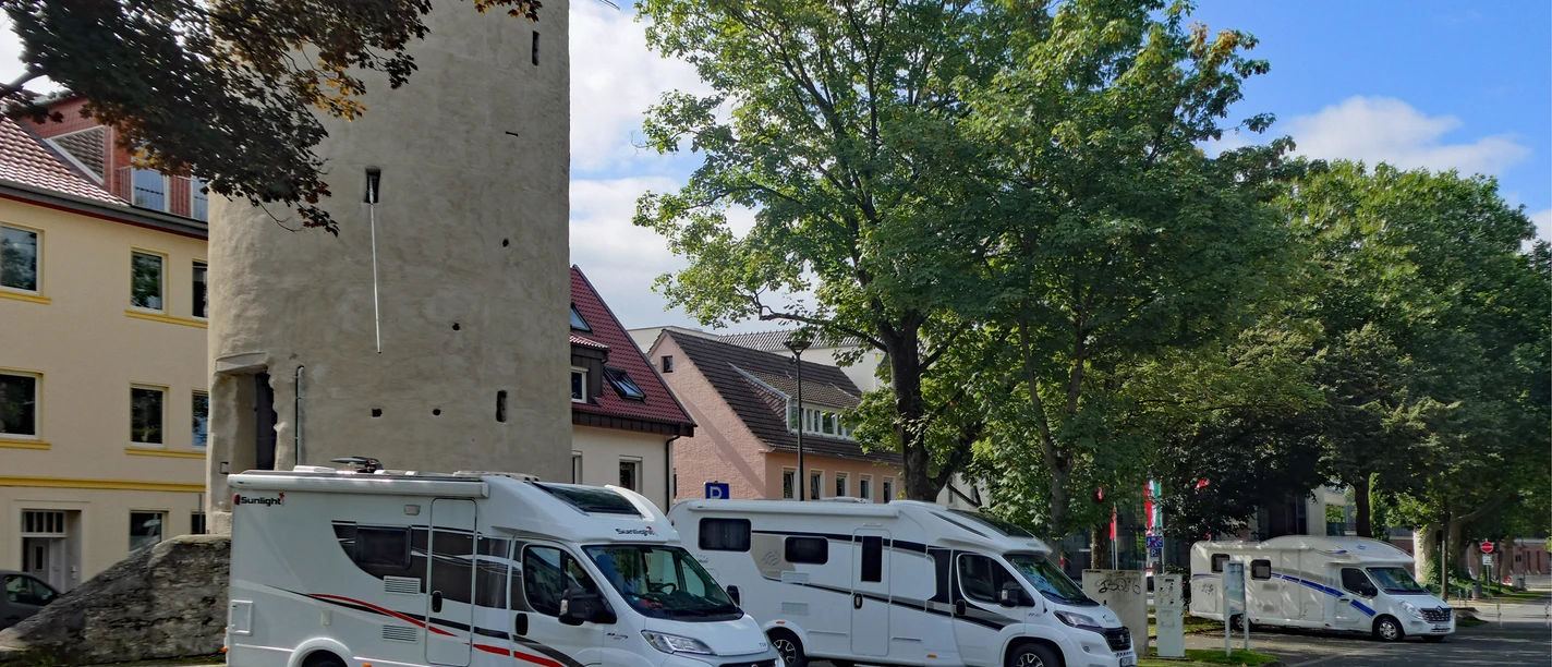 Wohnmobilstellplatz am Maspernplatz in städtischer Umgebung, nahe historischer Turm und viel Grün.
