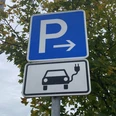 Symbolbild: E-Tankstelle Parkschild mit Elektroauto-Symbol in herbstlicher Umgebung, deutet auf Ladestation für E-Autos hin.