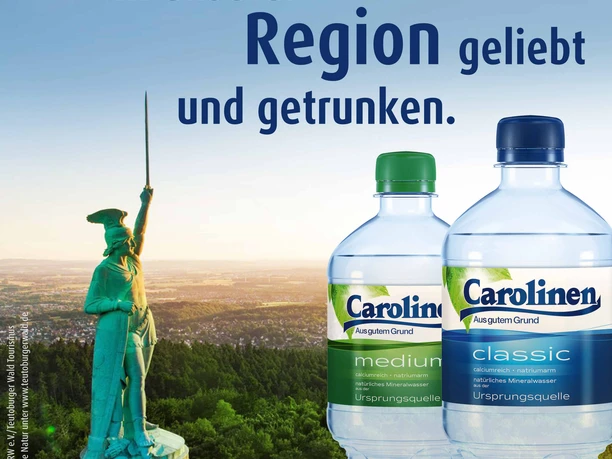 Carolinen Brunnen GmbH & Co. KG Zwei Carolinen Mineralwasserflaschen vor dem Hermannsdenkmal im Teutoburger Wald bei Sonnenuntergang.