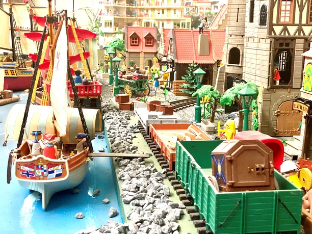 Miniwelten Lathen Detailreiche Miniaturlandschaft mit Segelschiff, Eisenbahn und historischen Gebäuden aus Spielmodellen.