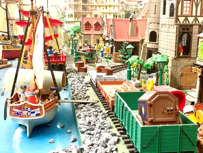Miniwelten Lathen Detailreiche Miniaturlandschaft mit Segelschiff, Eisenbahn und historischen Gebäuden aus Spielmodellen.