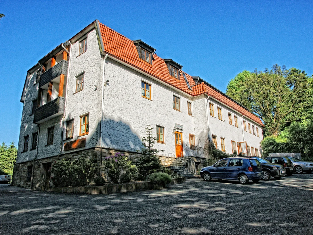 Forsthaus Limberg Forsthaus Limberg: Historisches Gebäude mit weißen Wänden, roten Dächern, parkende Autos davor.