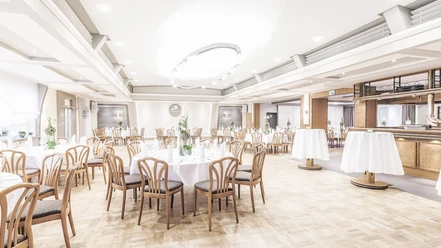 Gasthaus Kaiser-Dorfkrug Eleganter Veranstaltungsraum mit runden Tischarrangements, Holzstühlen und festlicher Beleuchtung.