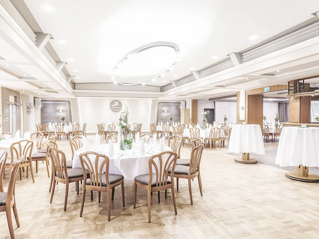 Gasthaus Kaiser-Dorfkrug Eleganter Veranstaltungsraum mit runden Tischarrangements, Holzstühlen und festlicher Beleuchtung.