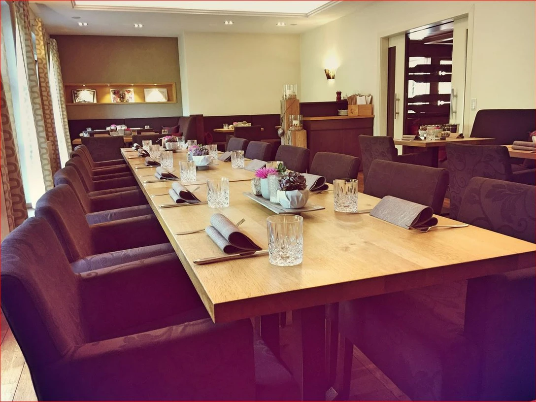 Gasthaus Kreft Innenraum eines gehobenen Restaurants mit gedecktem langen Tisch, Kristallgläsern und stilvoller Dekoration.