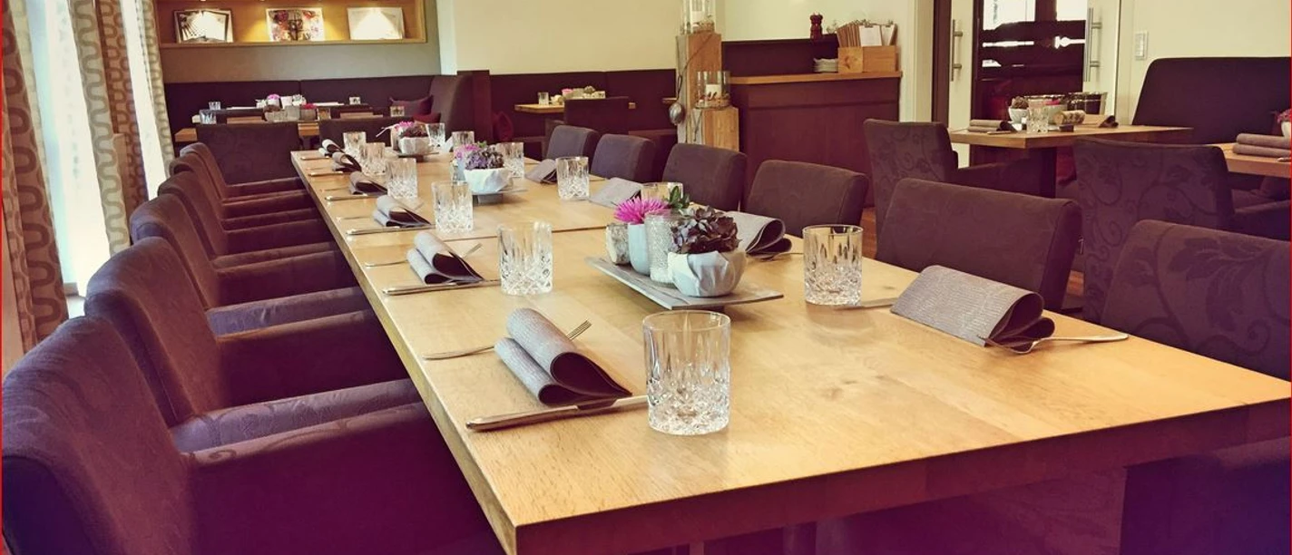 Gasthaus Kreft Innenraum eines gehobenen Restaurants mit gedecktem langen Tisch, Kristallgläsern und stilvoller Dekoration.