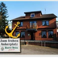 Gaststätte Zum frohen Anker_PrOldenorf.JPG Backsteingebäude zweistöckig mit Schindeldach, Holzbalkon und großen Fenstern; Schild mit gelbem Anker.