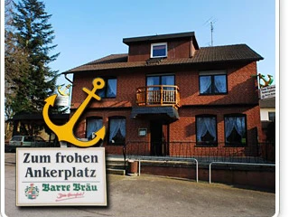 Gaststätte Zum frohen Anker_PrOldenorf.JPG Backsteingebäude zweistöckig mit Schindeldach, Holzbalkon und großen Fenstern; Schild mit gelbem Anker.