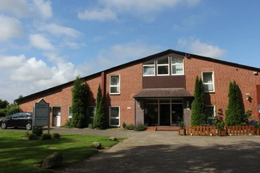 The Landhaus Wachendorf presents itself as an inviting brick building with a well-kept garden.