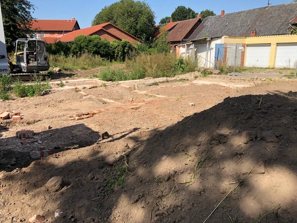 Ausgrabungsstätte einer historischen Synagoge in Hoya mit freigelegten Fundamenten und Baustrukturen.