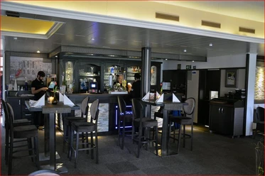 Griechisches Restaurant „Santorini“ Espelkamp.JPG Einladendes griechisches Restaurant mit Barbereich, stilvoll dekoriert und mehreren Sitzgelegenheiten.