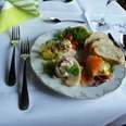 Hotel-Restaurant Lindenhof Ein liebevoll gedeckter Tisch mit Teller voller Fischvorspeisen, Brotscheiben und Salatgarnitur.