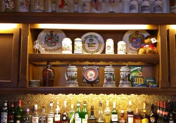 Hotel-Restaurant Lindenhof Eine rustikale Bar mit einer Auswahl an Getränken und dekorativen Bierkrügen ausgestellt in Regalen.