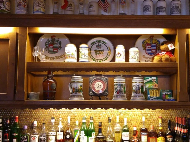 Hotel-Restaurant Lindenhof Eine rustikale Bar mit einer Auswahl an Getränken und dekorativen Bierkrügen ausgestellt in Regalen.