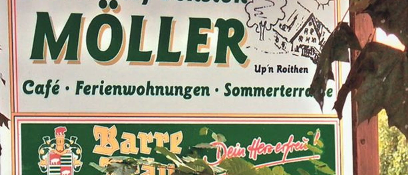 Landcafé Up n Roithen_PrOldendorf.jpg Schild der Bauernhof-Pension Möller mit Café, Ferienwohnungen und Sommerterrasse, umrahmt von Blättern.