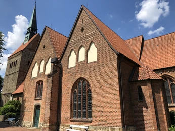 Kirche Vilsen Backstein-Gotik Kirche mit hohem Turm und spitzen Fenstern; blauer Himmel mit wenigen weißen Wolken.