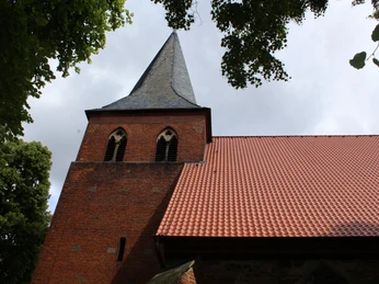 Die St. Laurentius-Kirche in Liebenau ist aus rotem Backstein erbaut und besitzt einen spitzen Turm.