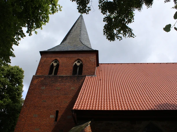 Die St. Laurentius-Kirche in Liebenau ist aus rotem Backstein erbaut und besitzt einen spitzen Turm.