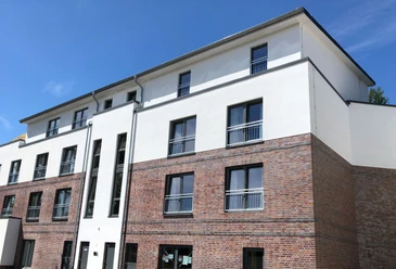 Modern residential complex with clean lines, blue skies and several floors in Nienburg an der Weser.
