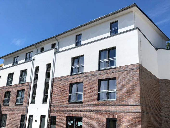 Moderne Wohnanlage mit klaren Linien, blauem Himmel und mehreren Etagen in Nienburg an der Weser.