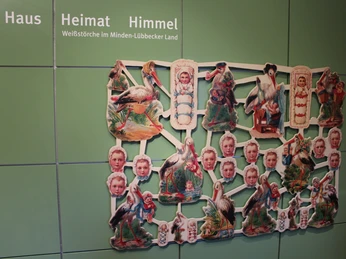 Storchenmuseum Windheim Ein farbenfrohes Puzzle an der Wand zeigt verschiedene Darstellungen von Weißstörchen und Kindern.