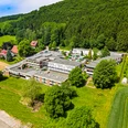 Wiehen Therme Luftaufnahme einer großen Therme umgeben von grünen Wiesen und Wäldern im Hintergrund.